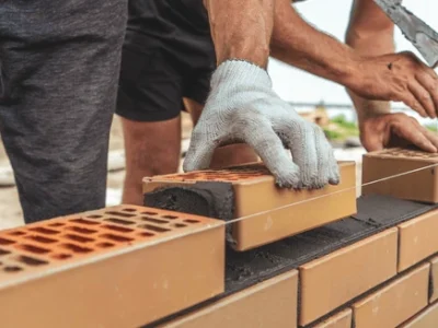 worker-mason-hands-laying-bricks